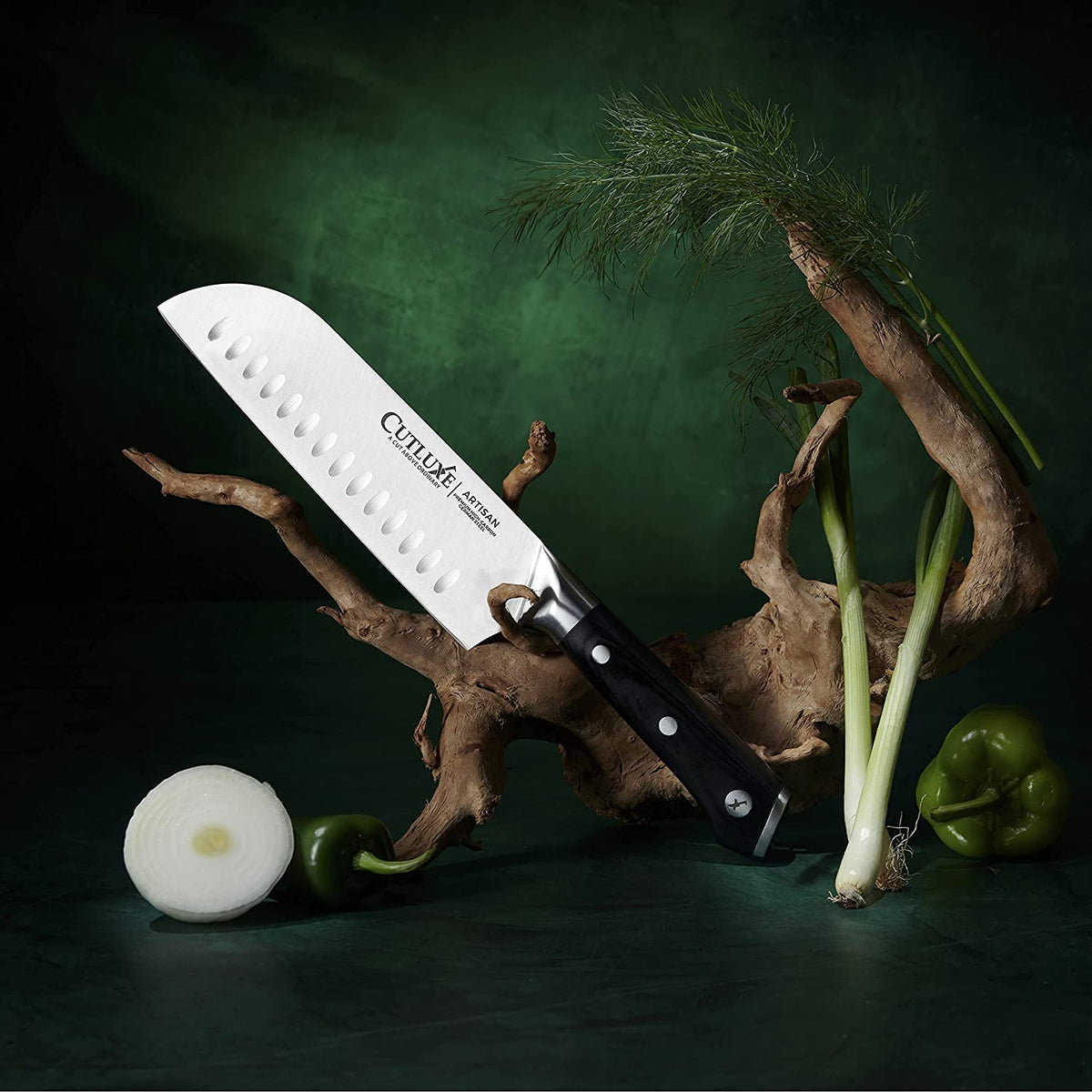 Product image 7 of 8: Cutluxe artisan chef knife with black handle, displayed with fresh green peppers, onions, and herbs on dark green background