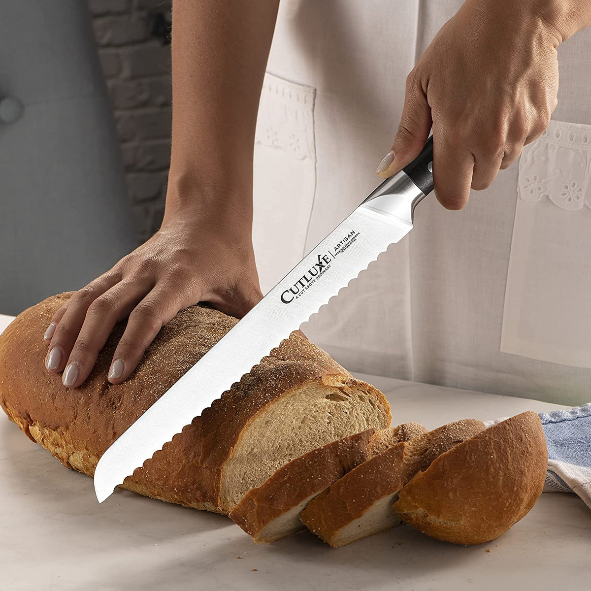 Product image 5 of 9: Slicing fresh bread with a serrated kitchen knife for home cooking