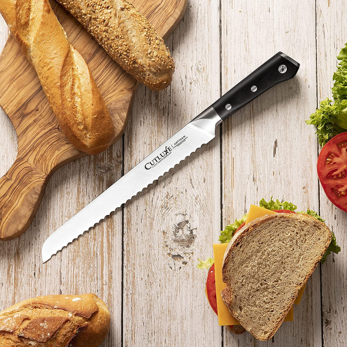 Product image 7 of 9: Serrated bread knife with black handle on rustic table, slicing fresh bread and sandwich ingredients
